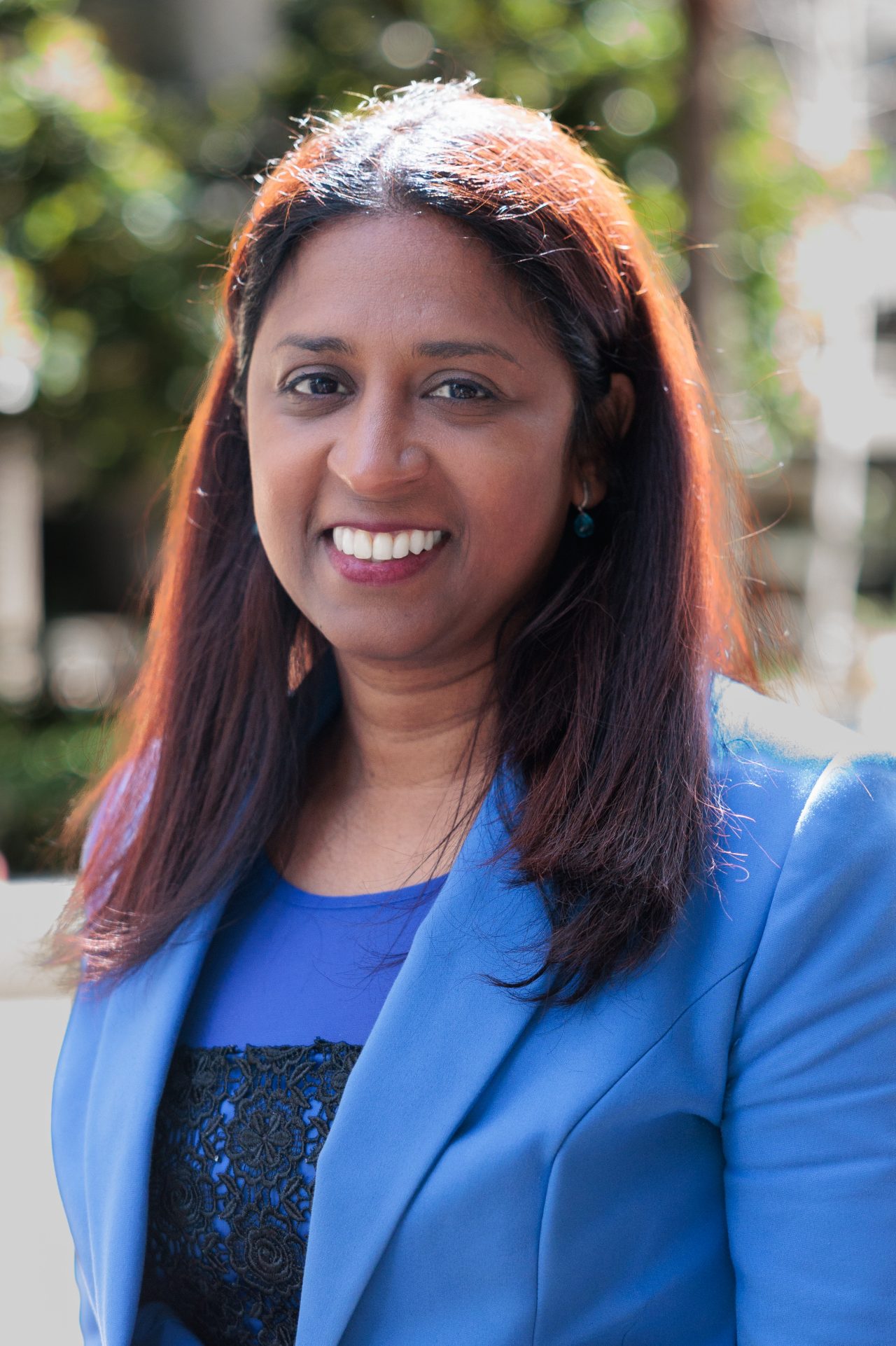 Denisha Anbu, Executive General Manager, Customer Experience, outdoors in a blue jacket