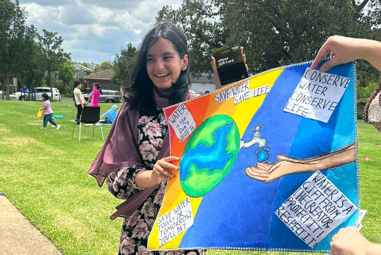 Girl holding colourful Communities in Fellowship Together poster