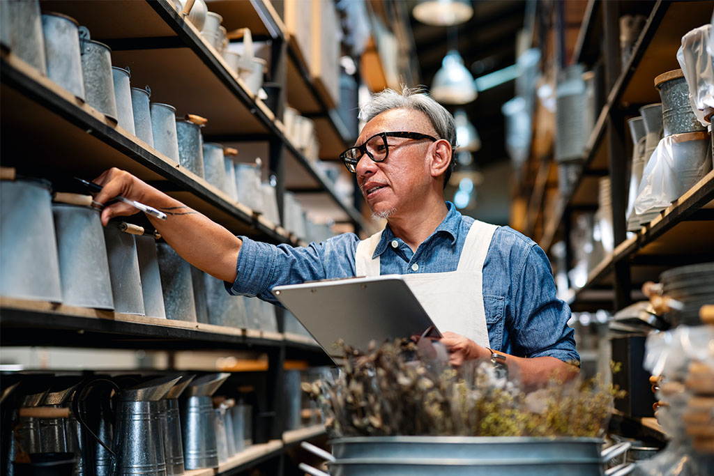 Business owner looking at stock on the shelf
