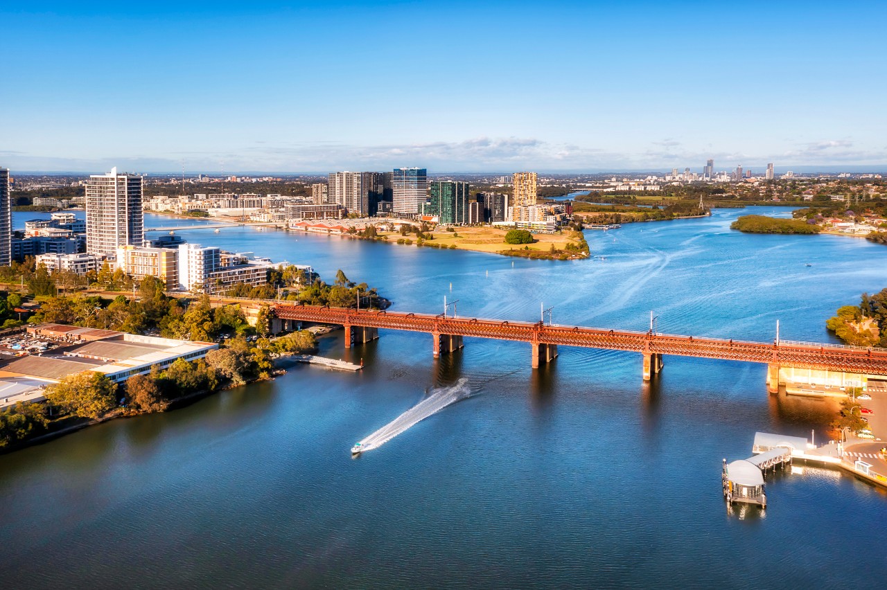 Aerial view of the Parramatta River, showing buildings, businesses and ferry wharves