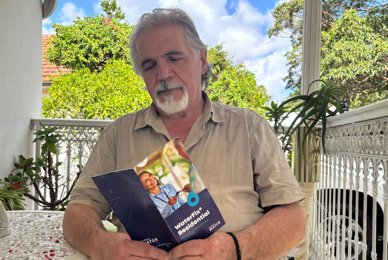 Customer Andreas Proestos holding WaterFix Residential flyer