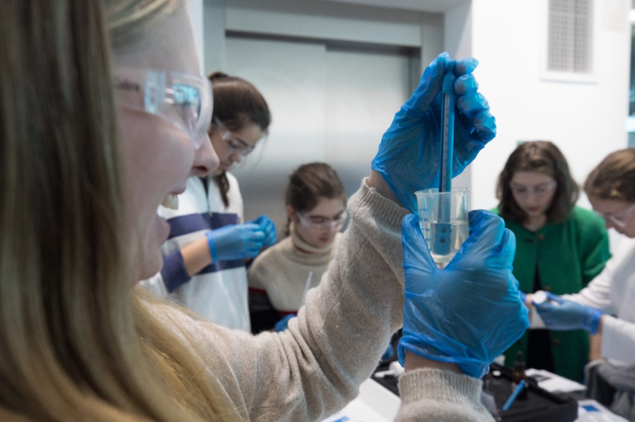 Teenagers in lab equipment, testing with water filtration devices. 