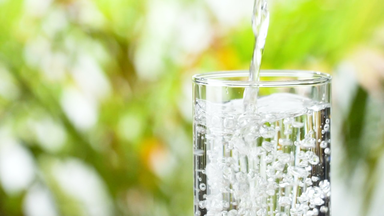 Closeup of a glass cup being filled with water. 