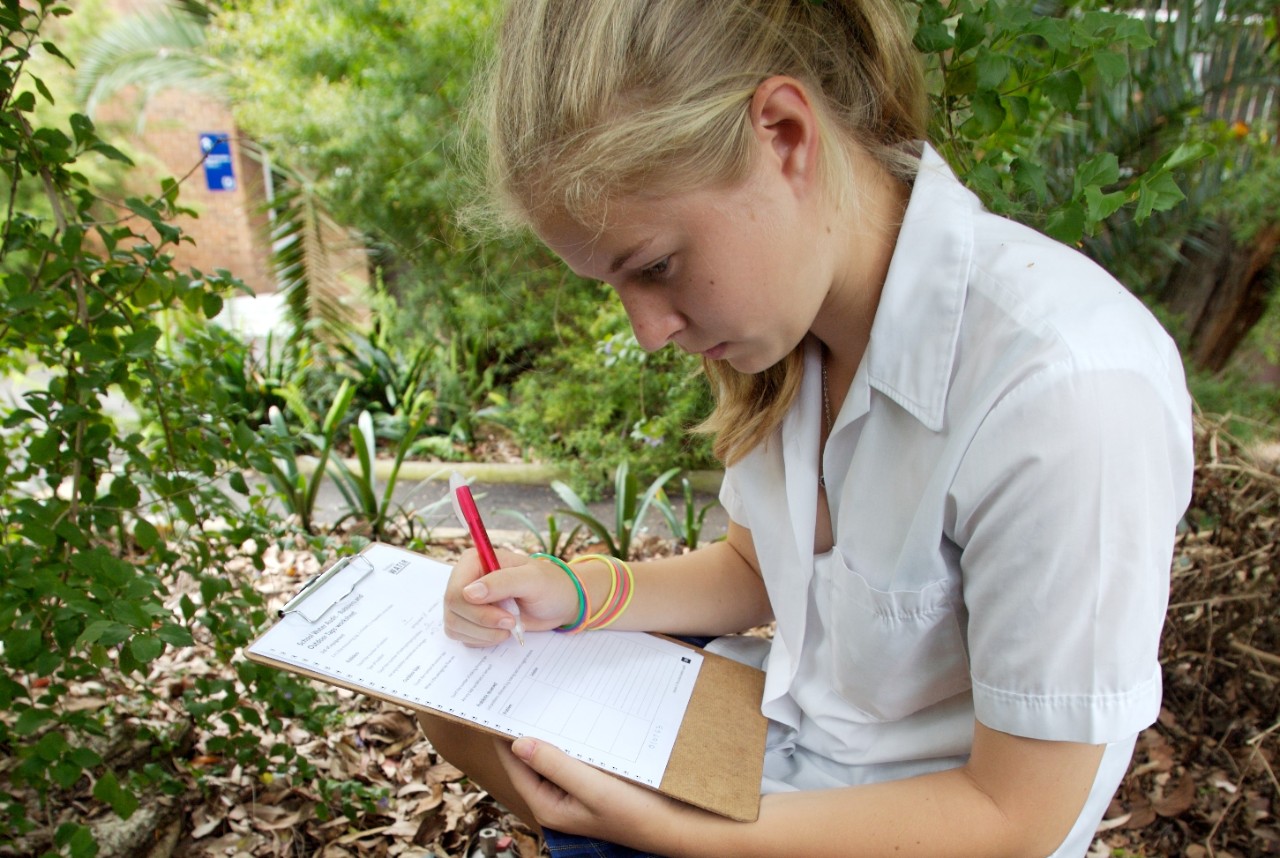Young girl working off a water audit worksheet.