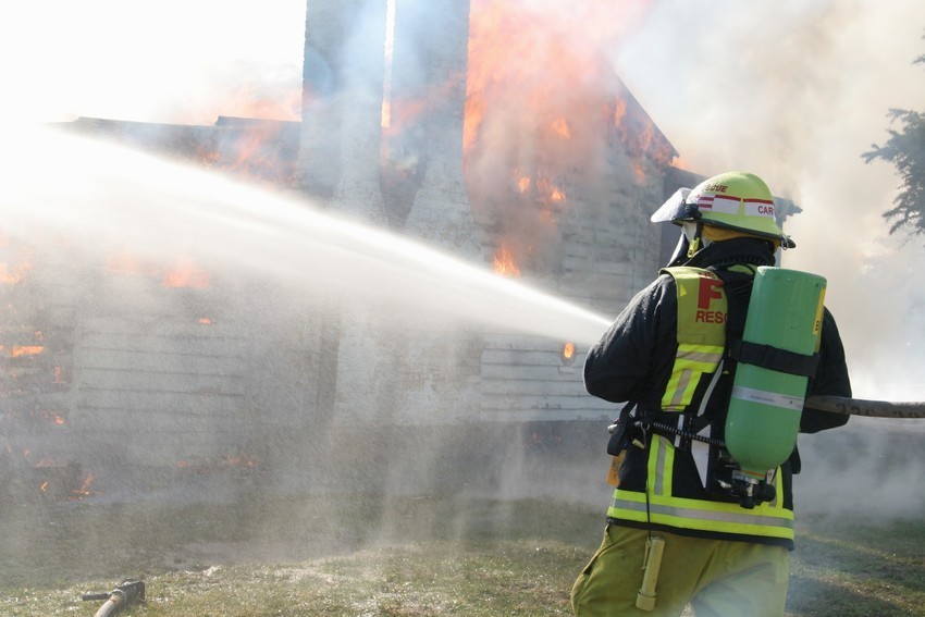 A photo of a fire fighter using recycled water to extinguish a fire.