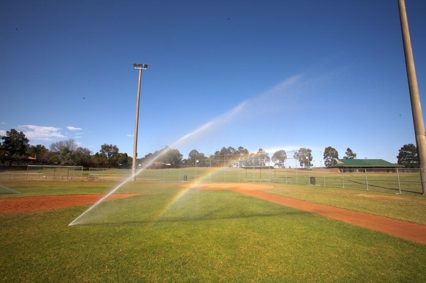 A photo of a sprinkler spraying recycled water onto a sports field.
