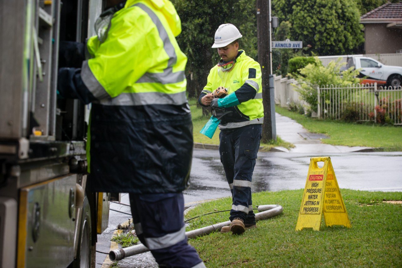 Sydney Water field staff responding to a suburban callout in rainy conditions.