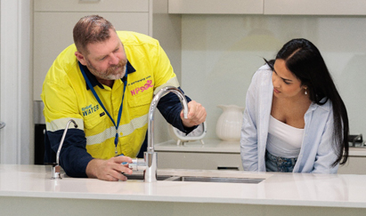 WaterFix Residential plumber discussing leaky tap with female customer