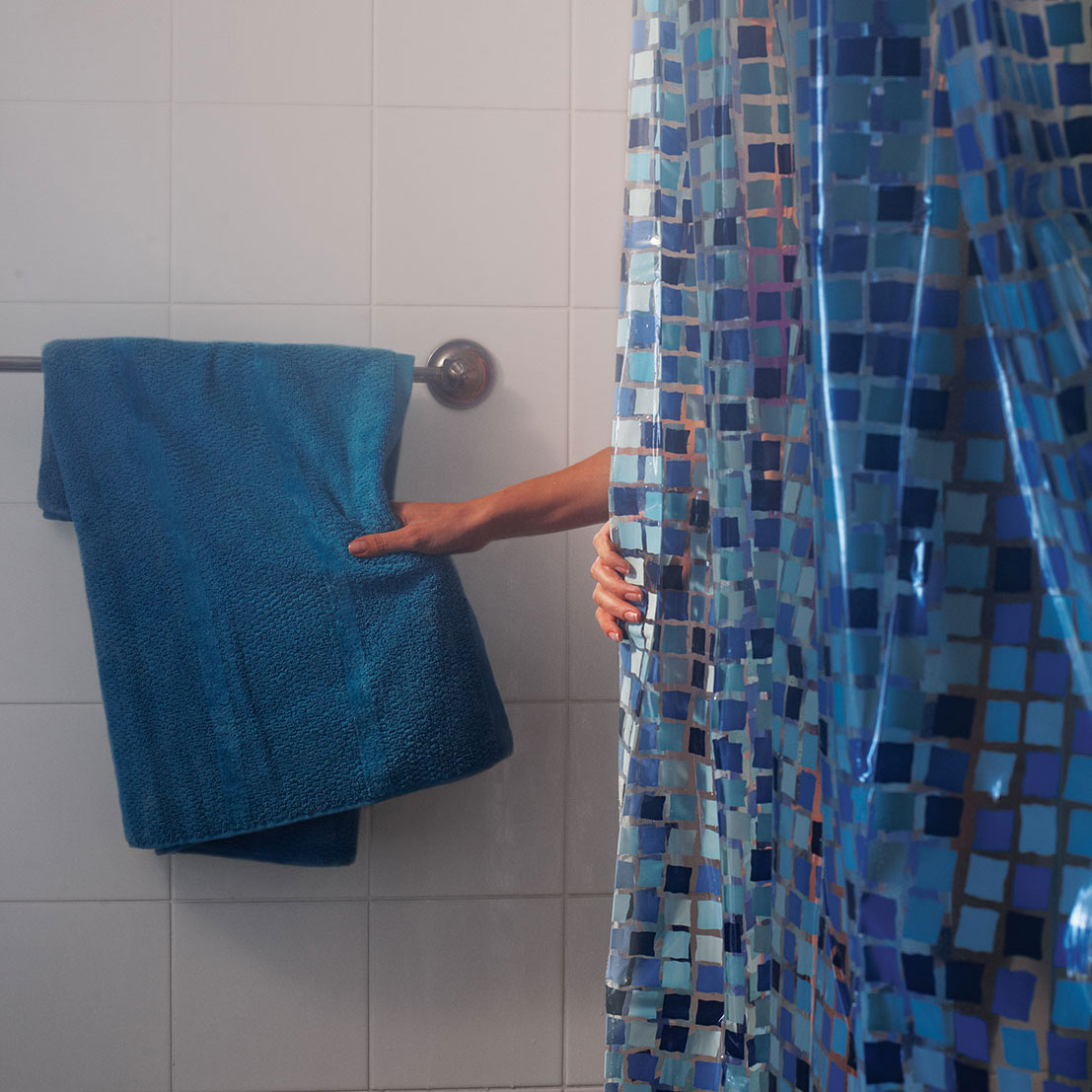 Person in shower reaching for a towel