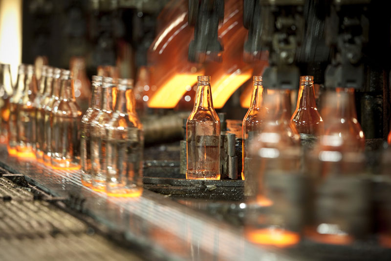 A production line of glass bottles being produced. 